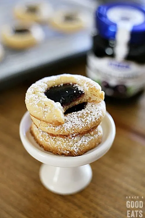 stack of thumbprint cookies on a small white dessert stand