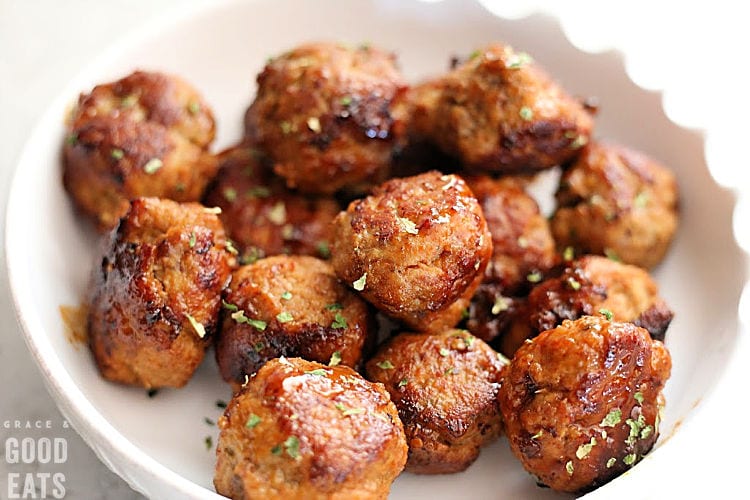 Honey Chipotle Meatballs garnished with green parsley in a white bowl