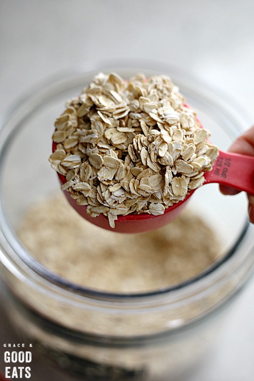 Scooping oats out of a glass jar