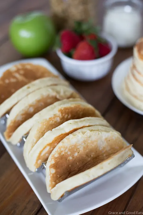 Pancake Parfait Tacos filled with yogurt, granola, apples, and strawberries and topped with a drizzle of honey.  Serve with breakfast potatoes or scrambled eggs for an easy, kid-friendly breakfast!