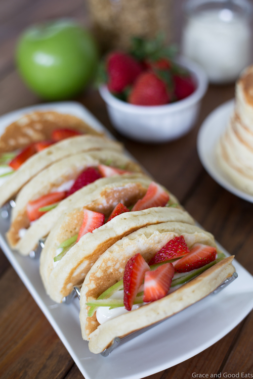 Pancake Parfait Tacos filled with yogurt, granola, apples, and strawberries and topped with a drizzle of honey.  Serve with breakfast potatoes or scrambled eggs for an easy, kid-friendly breakfast!