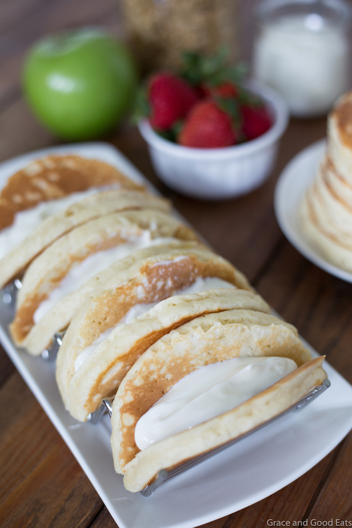 Pancake Parfait Tacos filled with yogurt, granola, apples, and strawberries and topped with a drizzle of honey.  Serve with breakfast potatoes or scrambled eggs for an easy, kid-friendly breakfast!