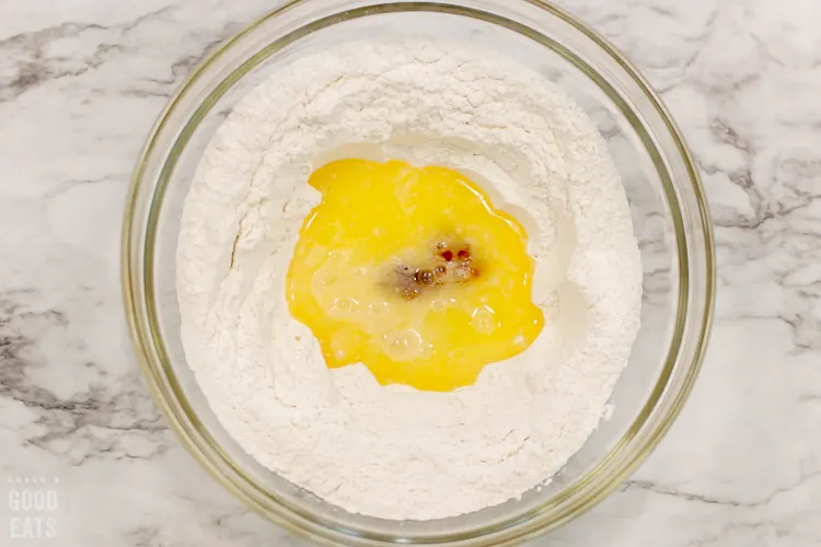 butter, eggs, and vanilla in the center of dry ingredients in a glass bowl
