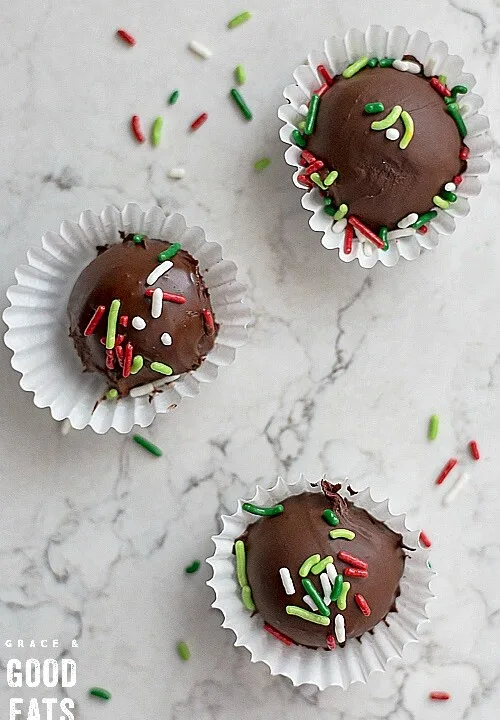 three chocolate truffles in small wrappers with holiday sprinkles