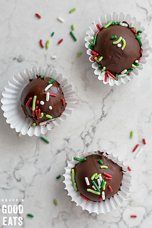 three chocolate truffles in small wrappers with holiday sprinkles
