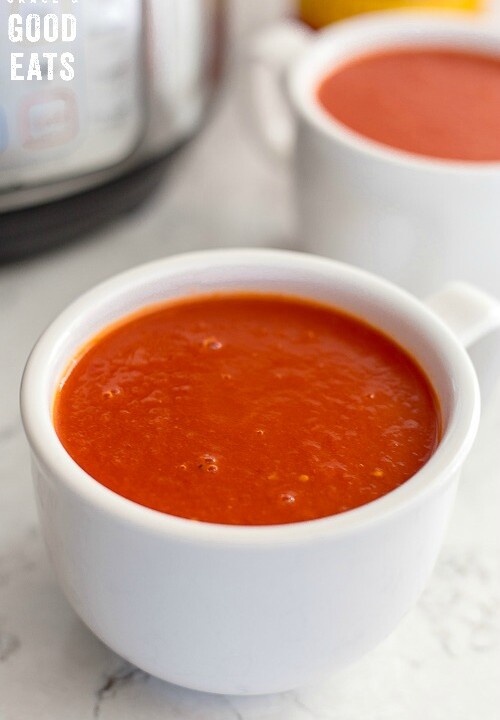 two bowls of tomato soup next to an Instant Pot pressure cooker