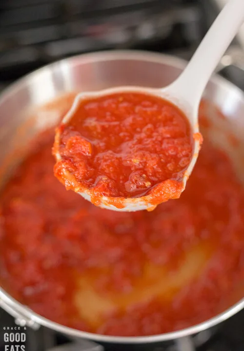 ladle full of marinara sauce over the stove