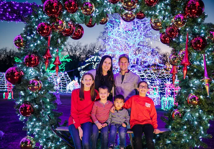 family posing under Christmas lights