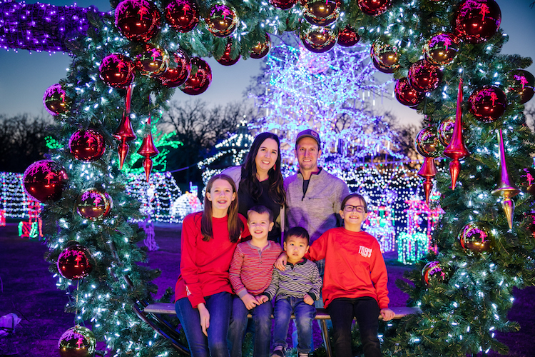 family posing under Christmas lights