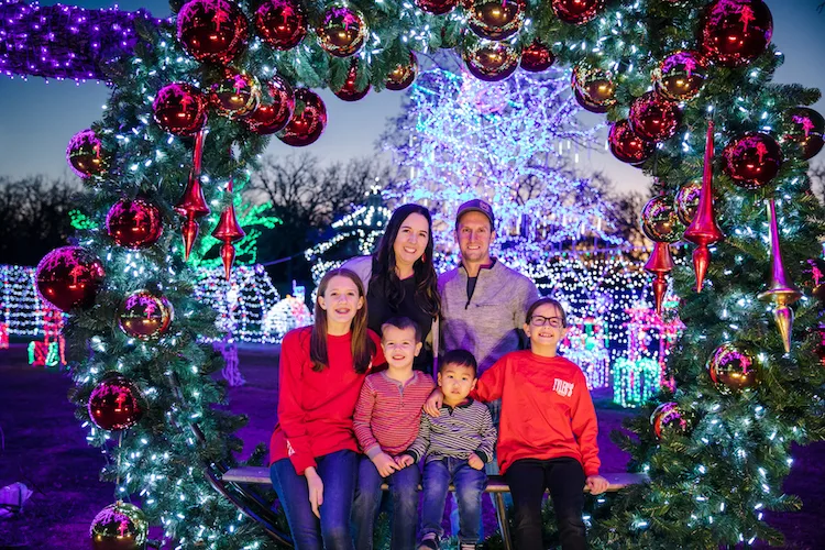family posing under Christmas lights