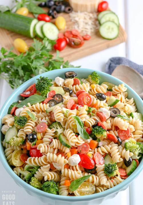 bowl of Italian Pasta Salad with ingredients in the background