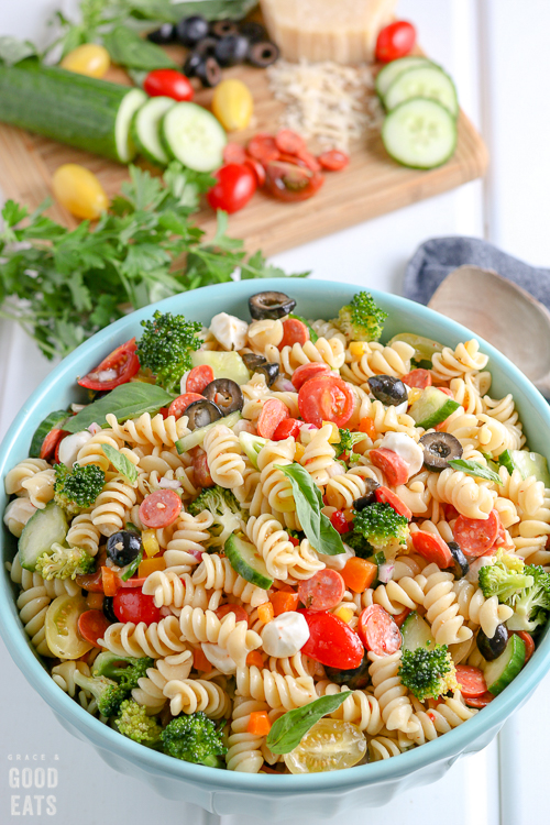 bowl of Italian Pasta Salad with ingredients in the background