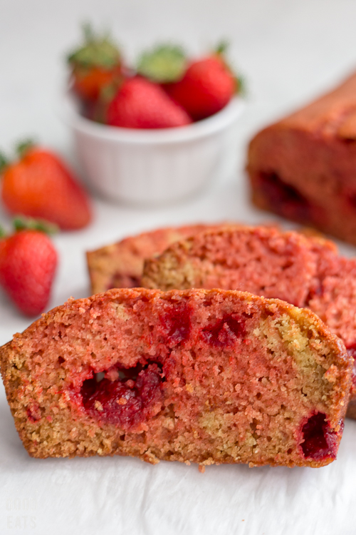 strawberry bread next to a bowl of fresh strawberries