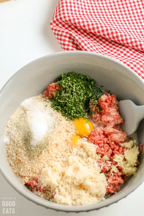 ingredients for meatballs in a mixing bowl before being combined