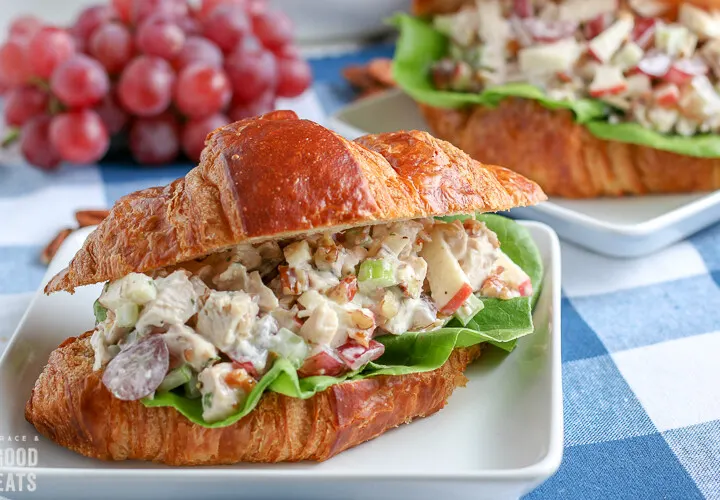 chicken salad sandwich with grapes in the background