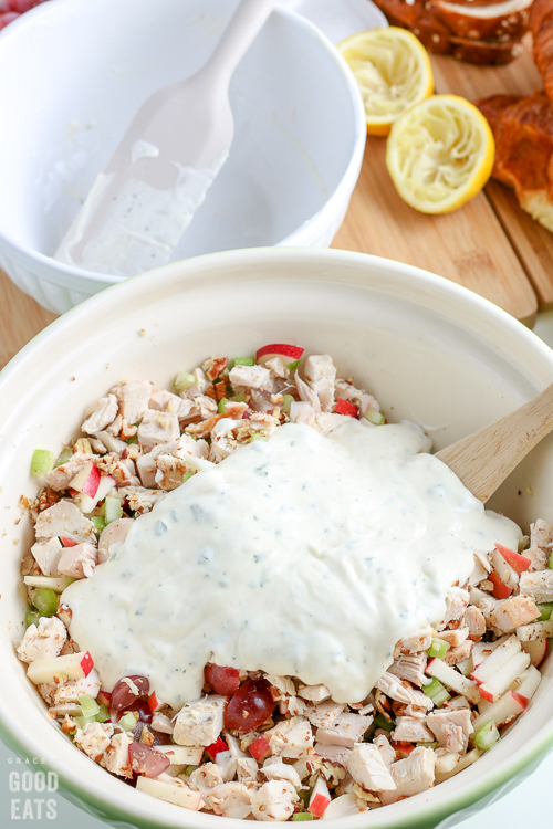 chicken salad ingredients with a mayonnaise mixture on top about to be mixed together