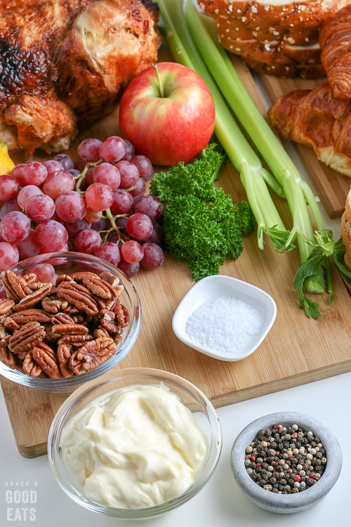 grapes, apples, celery, pecans scattered on a cutting board