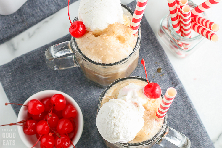 cropped view of ice cream floats next to a bowl of cherries