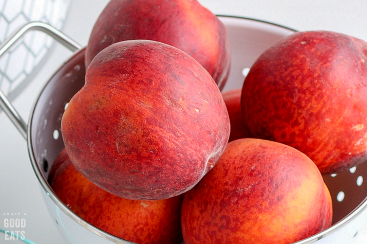 colander full of fresh peaches