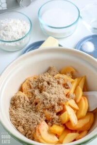 brown sugar and sliced peaches in a mixing bowl