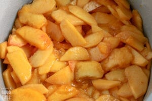 sliced peaches mixed with sugar in a bowl