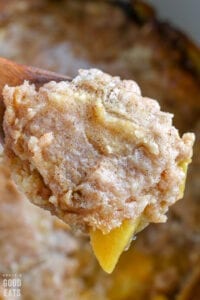 wooden spoon with a scoop of peach cobbler