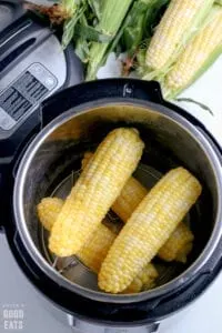 four cooked ears of corn in a pressure cooker