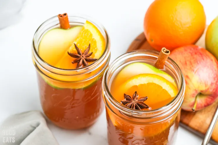 cider in a glass jar with orange slices and cinnamon sticks