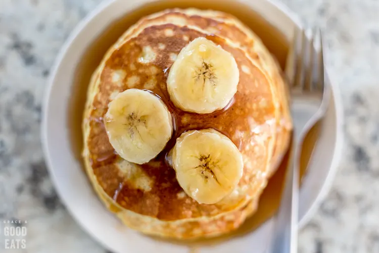 3 ingredient pancakes topped with bananas on a plate with a fork