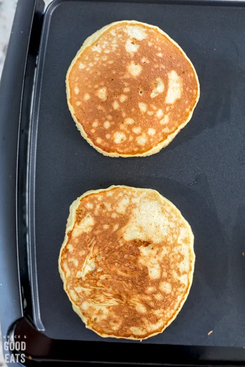 two pancakes on a griddle