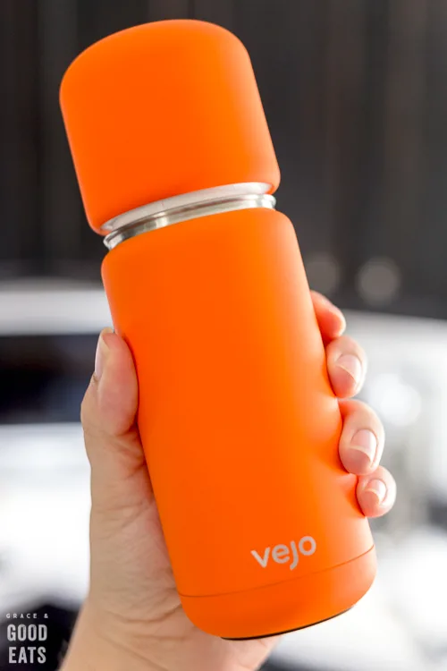 hand holding up an orange vejo blender