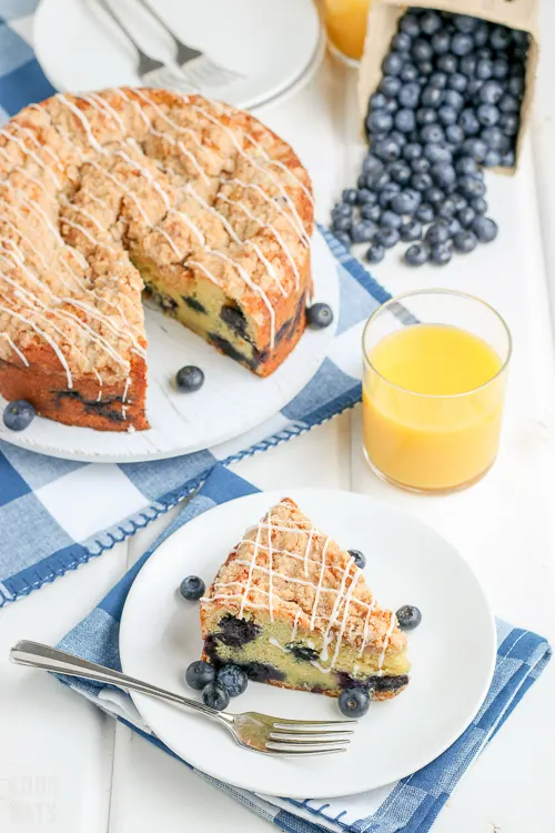 blueberry coffee cake with blueberries spilling out of a container