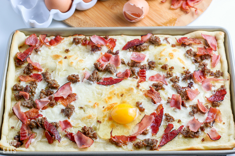 uncooked breakfast pizza with eggs