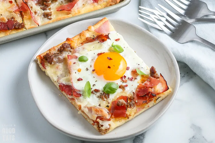 slice of breakfast pizza with a sunny side up egg