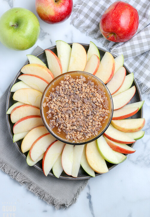 overhead view of a bowl of caramel apple dip with apples around it