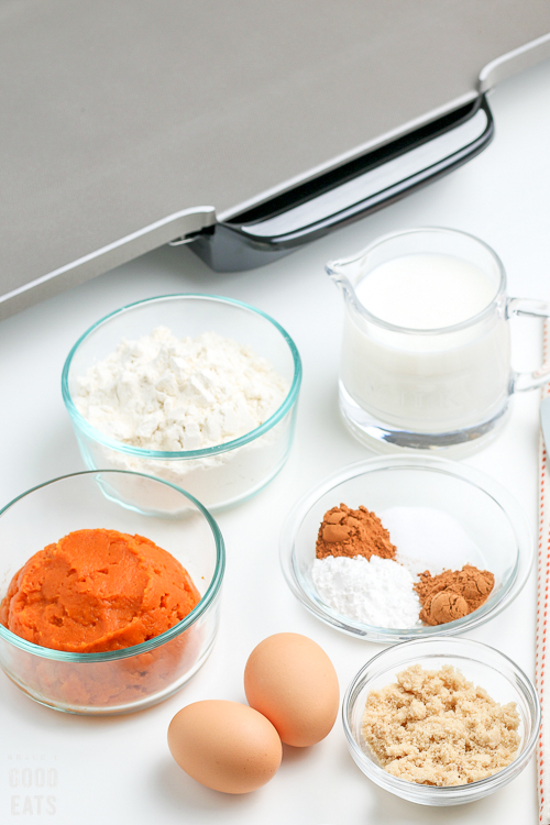 pumpkin pancake ingredients in small glass bowls next to a griddle