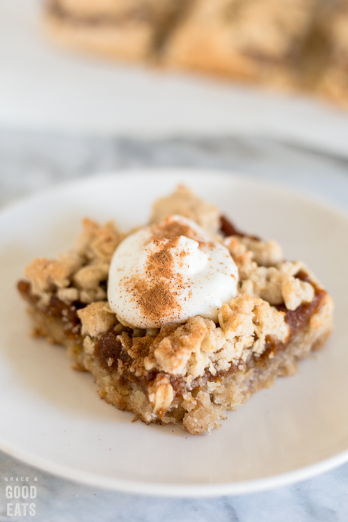 pumpkin bar on a plate with a dollop of whipped cream