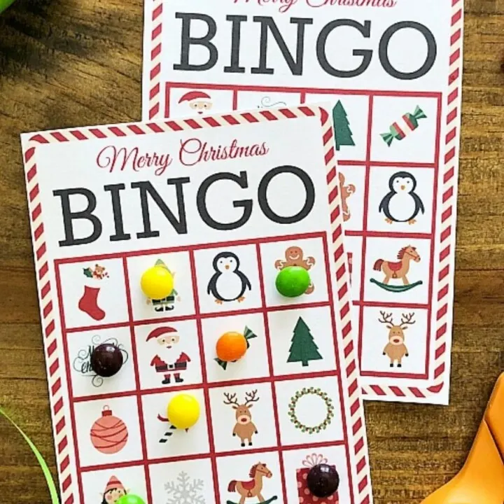 Christmas bingo cards next to ribbon and scissors