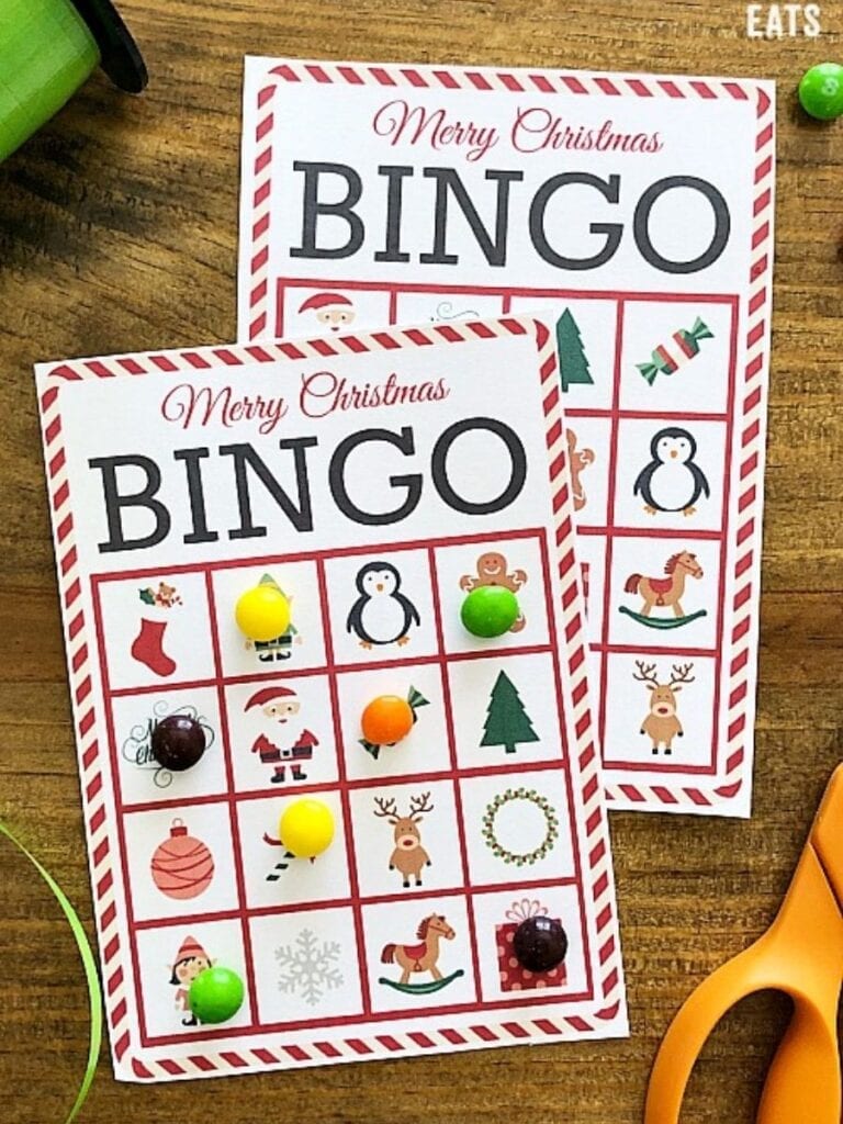 Christmas bingo cards next to ribbon and scissors