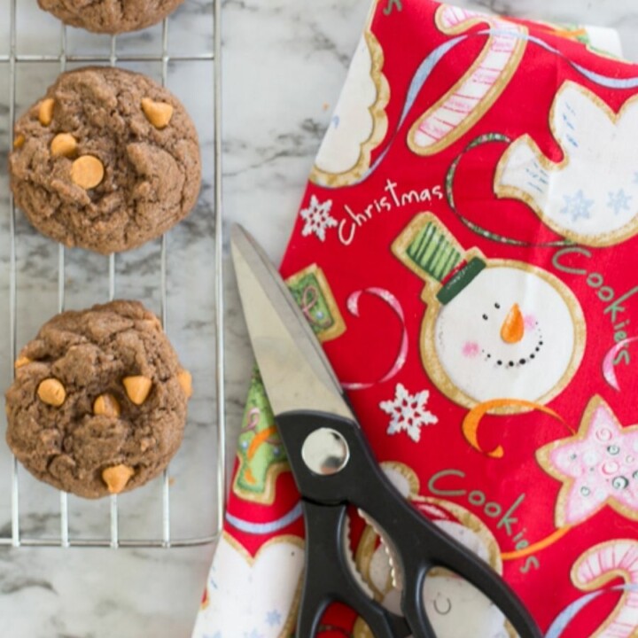 butterscotch cookies on a wire rack next to Christmas fabric and scissors