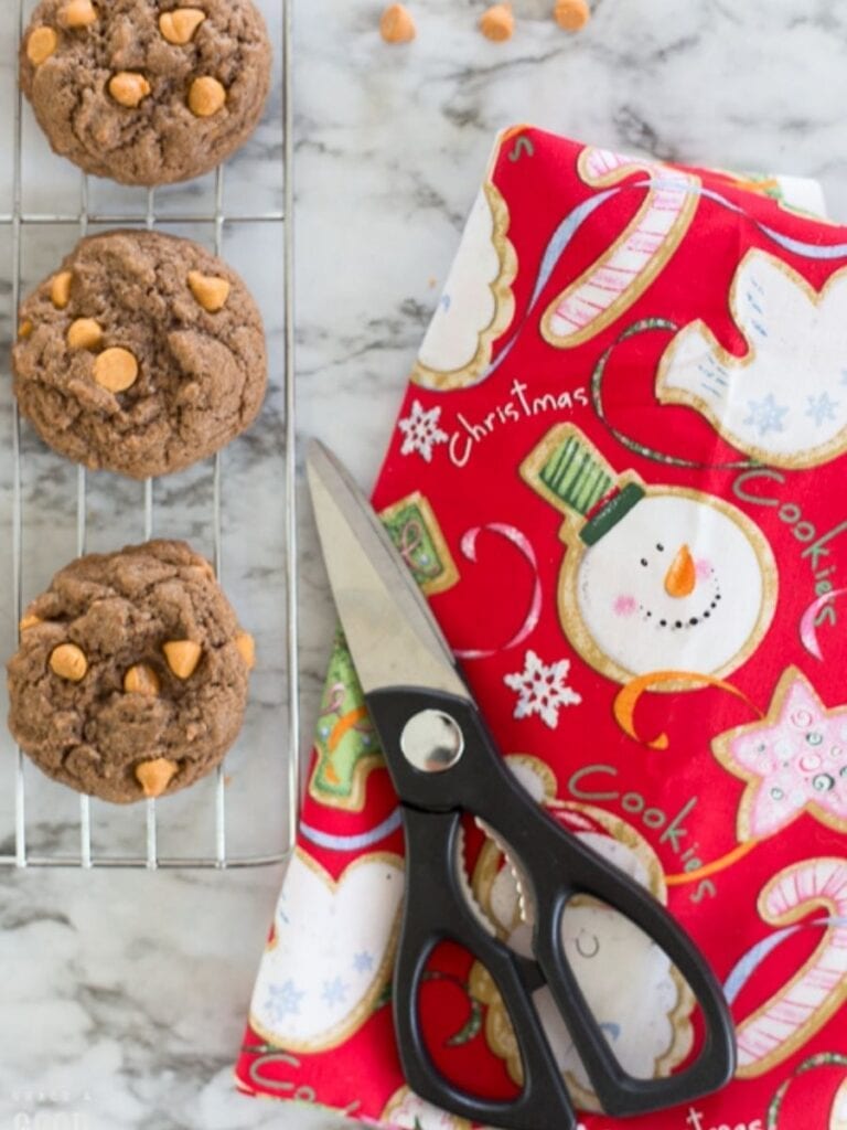 butterscotch cookies on a wire rack next to Christmas fabric and scissors
