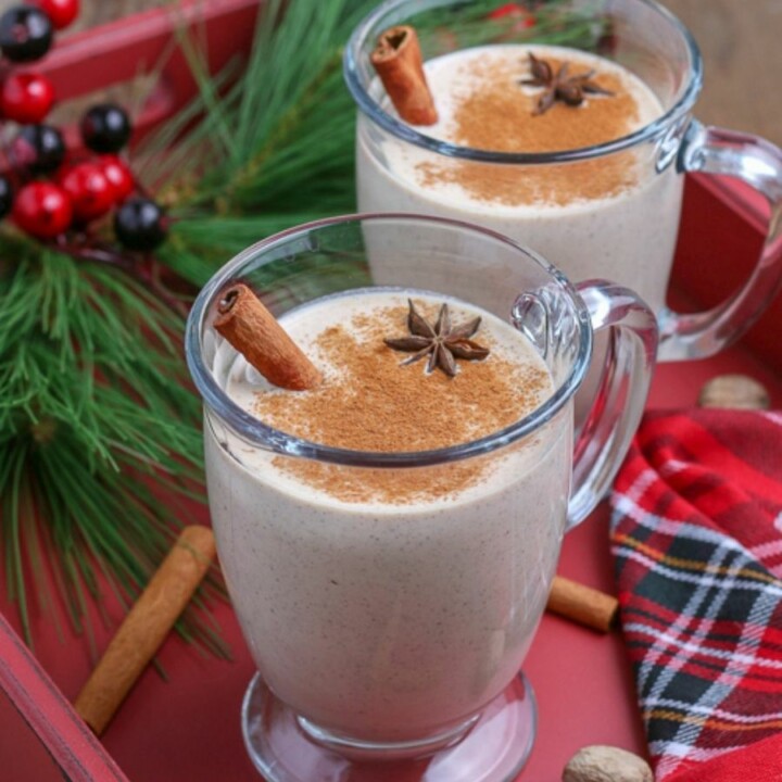 eggnog in a glass mug on a red tray