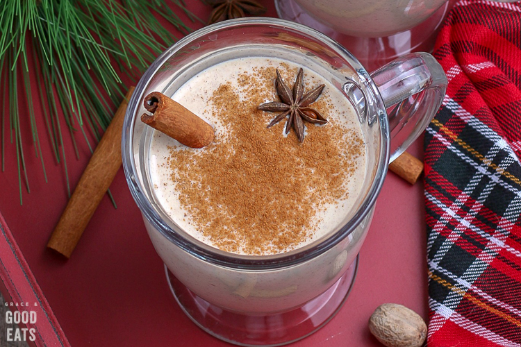 closeup of a glass mug with eggnog and a dusting of cinnamon