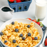 bowl of pancake cereal with berries in the background