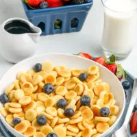 bowl of pancake cereal with berries in the background