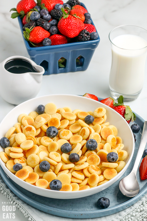 bowl of pancake cereal with berries in the background