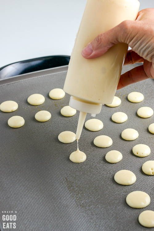 squeeze bottle dropping batter on a griddle