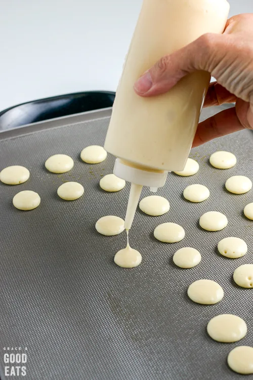 squeeze bottle dropping batter on a griddle