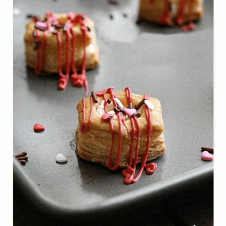 puff pastry bites with white chocolate and sprinkles on a baking sheet