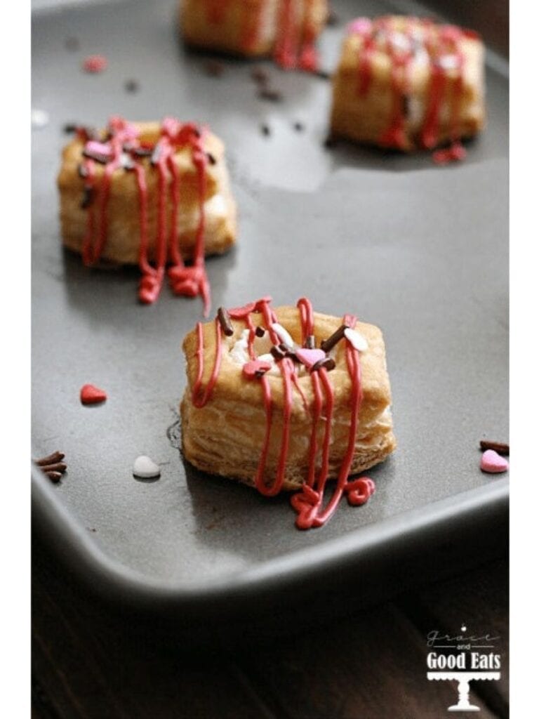 puff pastry bites with white chocolate and sprinkles on a baking sheet